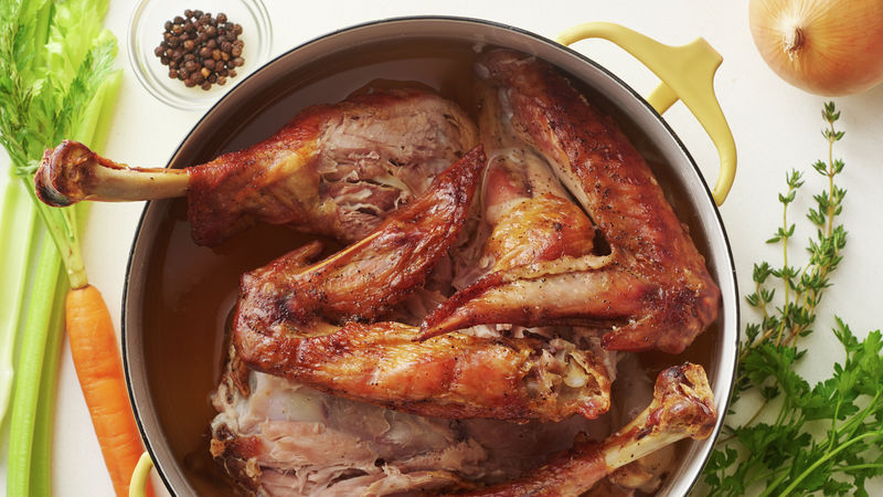 Turkey-in-bone in turkey stock in a pot