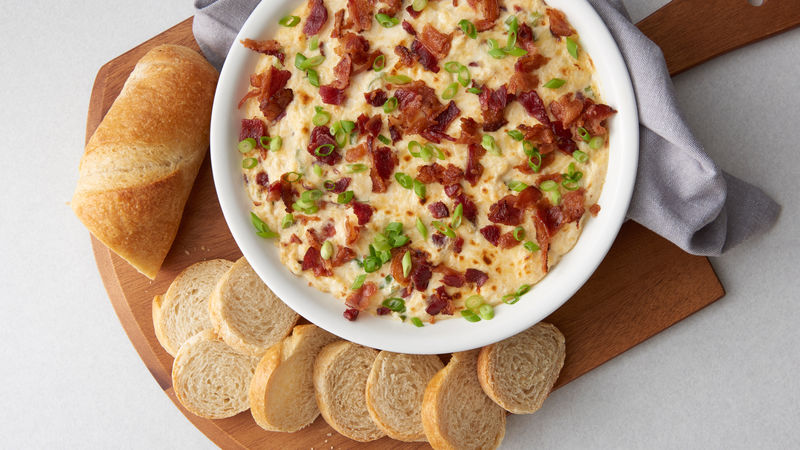 Smoked Gouda and Bacon Dip prepared recipe in a bowl surrounded by sliced bread